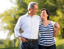 An older couple walk arm in arm.