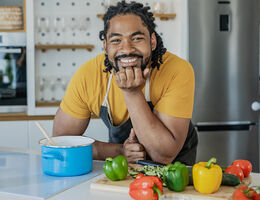 A smiling man in a kitchen.