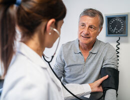 A doctor measures a man's blood pressure.