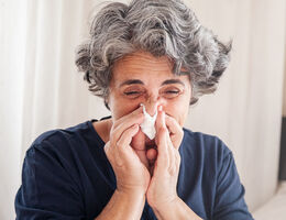 A woman blows her nose.